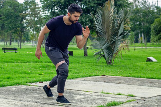 jovem treinando com bandas elásticas fazendo exercício de braço ao ar livre em um parque