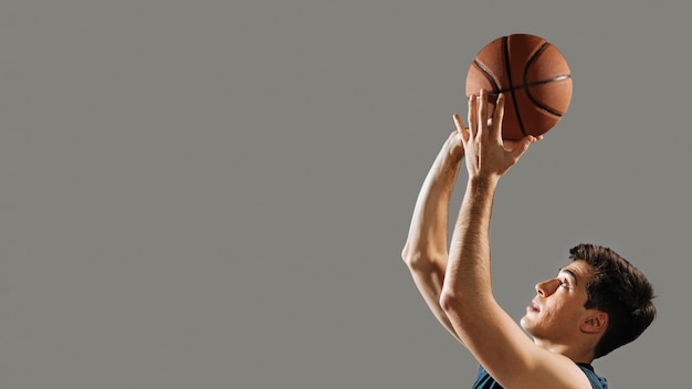 Jovem treinando para jogo de basquete com espaço de cópia