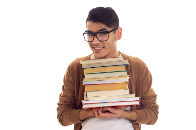 Jovem triste em camiseta branca cardigan marrom com óculos escuros segurando uma pilha de livros