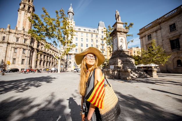 Jovem turista caminhando com bandeira catalã na praça Antonio Lopez, na cidade de Barcelona
