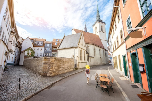 Jovem turista com chapéu amarelo andando na rua na cidade velha de Erfurt, na Alemanha