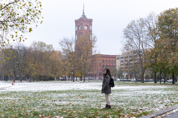 Jovem turista com o Rotes Rathaus ao fundo e arredores nevados