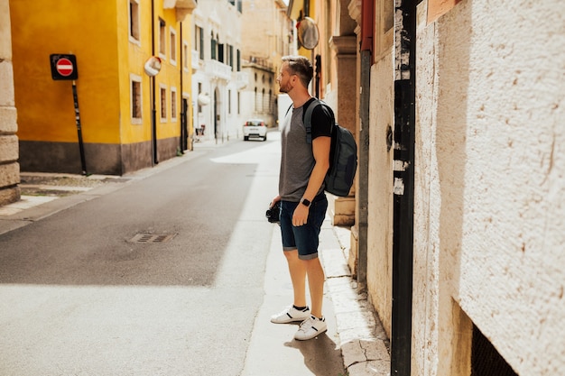 Jovem turista elegante com mochila explorando as ruas de Verona, Itália