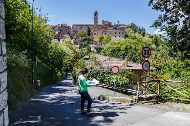 Jovem turista estudando o mapa de Montepulciano, na província de Sienna, na Toscana, Itália