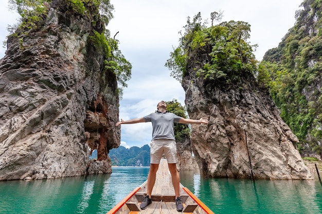 Jovem turista feliz em um barco longtail perto das famosas três rochas
