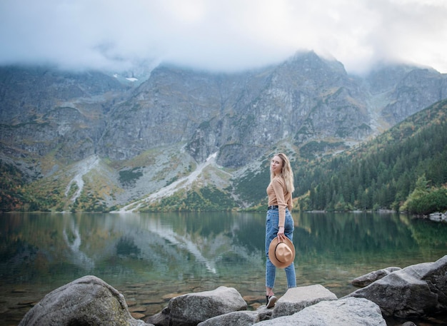 Jovem turista sentada no pico da montanha e belas montanhas