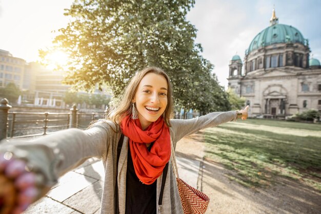 Jovem turista tirando fotos de selfie em frente à famosa catedral na cidade de Berlim