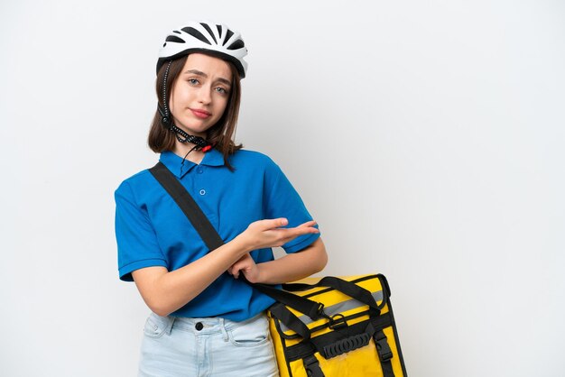 Jovem ucraniana com mochila térmica isolada em fundo branco apresentando uma ideia enquanto olha sorrindo para