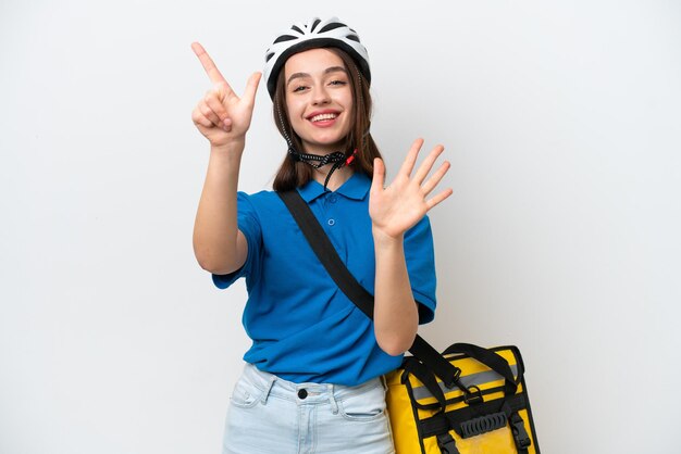 Jovem ucraniana com mochila térmica isolada em fundo branco contando sete com os dedos