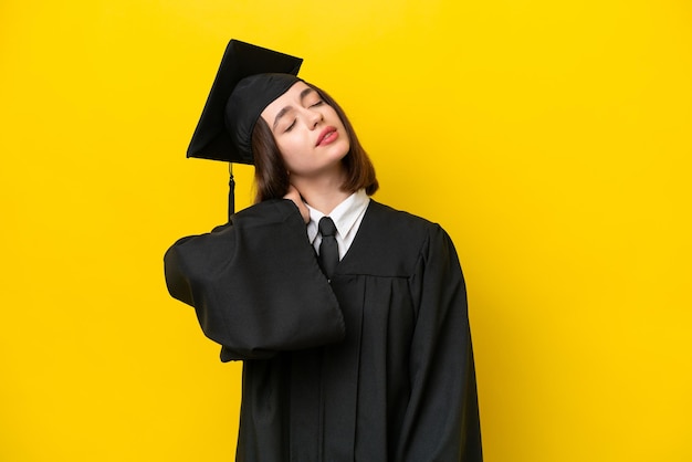 Jovem ucraniana graduada em universidade isolada em fundo amarelo com dor no pescoço