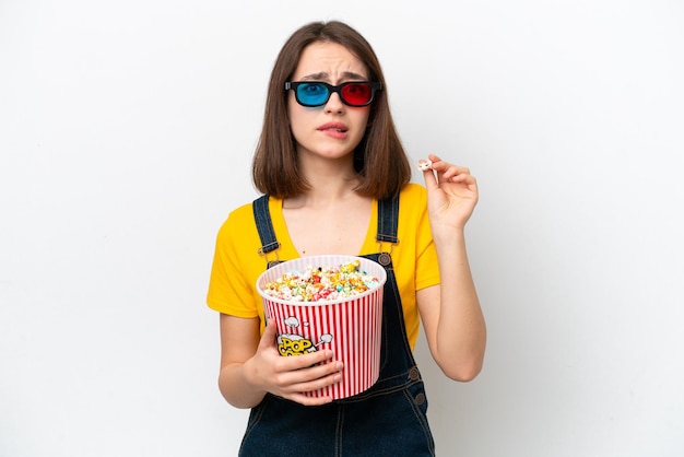 Jovem ucraniana isolada em fundo branco com óculos 3d e segurando um grande balde de pipocas