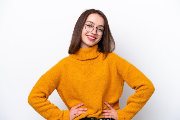 Jovem ucraniana isolada em fundo branco posando com braços no quadril e sorrindo