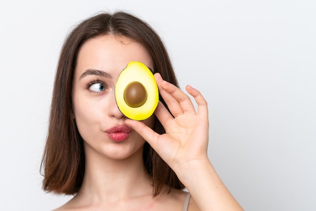 Jovem ucraniana isolada em fundo branco segurando um abacate Feche o retrato