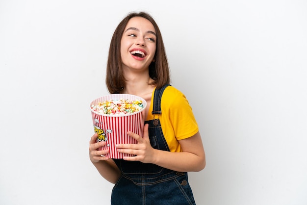 Jovem ucraniana isolada em fundo branco segurando um grande balde de pipocas