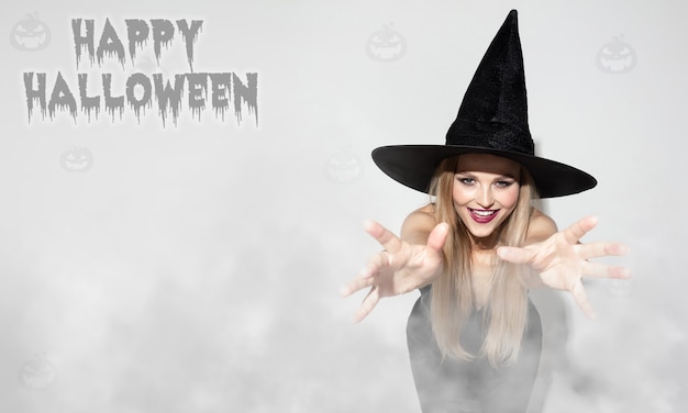Jovem, uma bruxa em um fundo assustador, panfleto de halloween