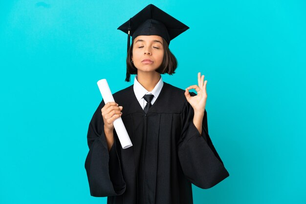 Jovem universitária sobre fundo azul isolado em pose zen