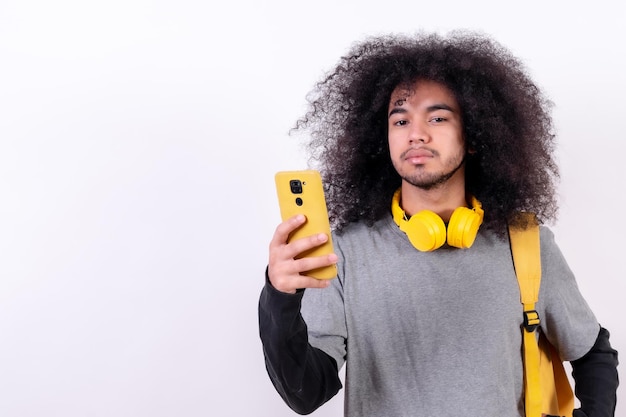 Jovem universitário com cabelo afro em fundo branco, ouvindo música