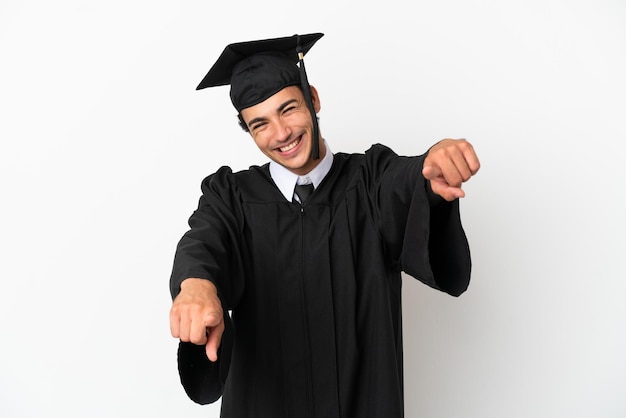 Jovem universitário com fundo branco isolado apontando o dedo para você enquanto sorri