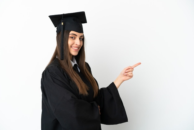 Jovem universitário isolado em um fundo branco apontando o dedo para o lado