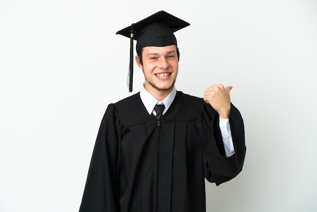 Jovem universitário russo formado isolado em um fundo branco apontando para o lado para apresentar um produto