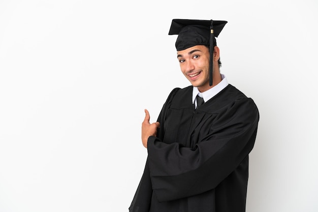 Jovem universitário sobre fundo branco isolado apontando para trás