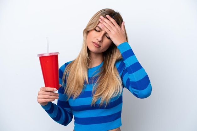 Jovem uruguaia bebendo refrigerante isolado no fundo branco com dor de cabeça