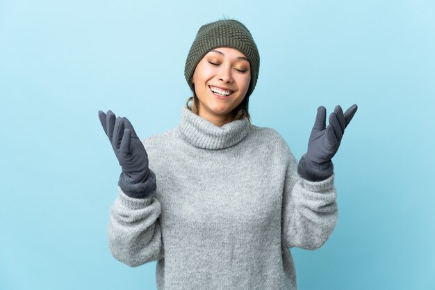 Jovem uruguaia com chapéu de inverno isolado na risada azul