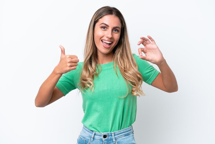 Foto jovem uruguaia isolada no fundo branco mostrando sinal ok e polegar para cima gesto