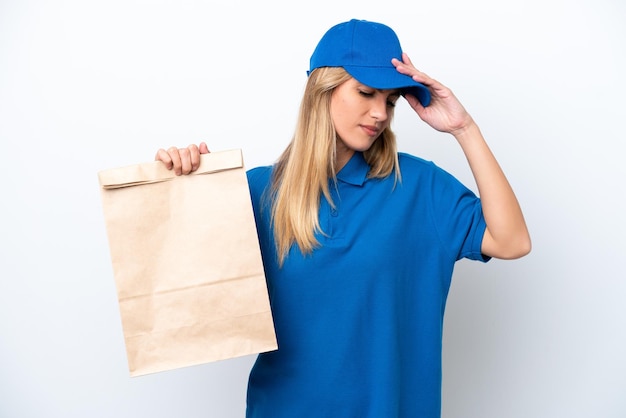 Jovem uruguaia tomando um saco de comida para viagem isolada no fundo branco com dor de cabeça