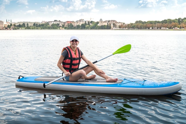 Jovem usa colete salva-vidas em um lindo lago em um dia quente de verão