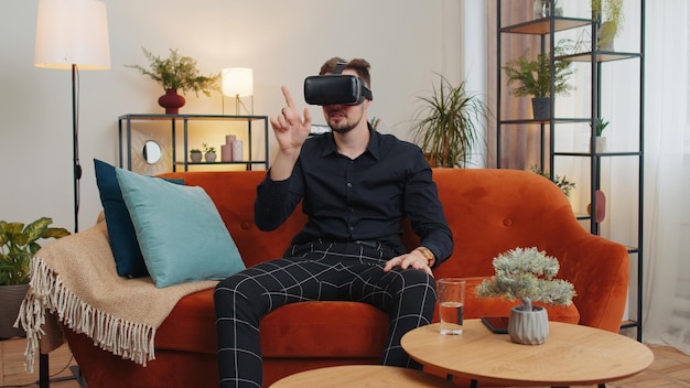 Foto jovem usa óculos de realidade virtual em casa joga videogame 3d fazendo gestos com as mãos