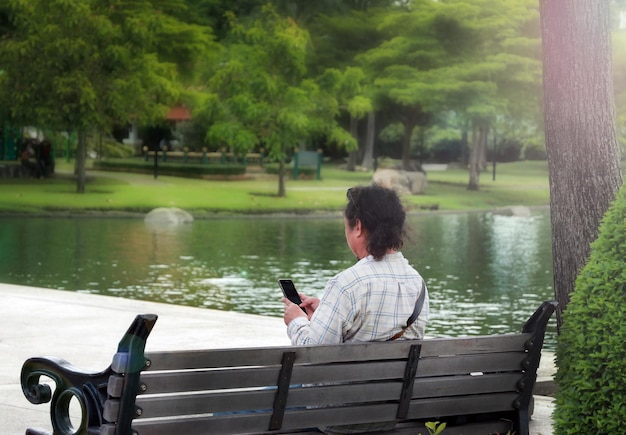 Jovem usa um smartphone no parque