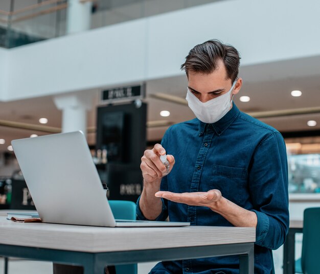 Jovem usando anti-séptico enquanto trabalha