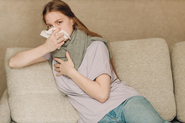 Jovem usando cachecol está com gripe, doente, doente, frio em casa, dentro de casa