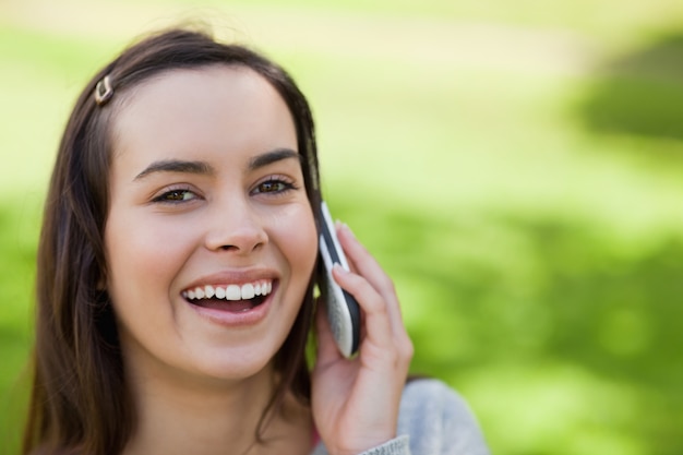 Jovem, usando, celular, telefone, parque, enquanto, rir