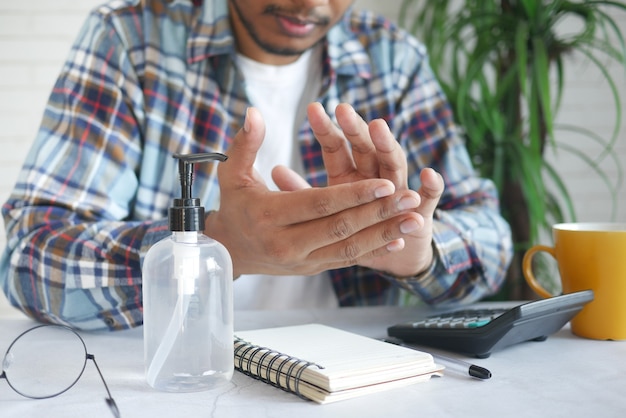 Jovem usando desinfetante para as mãos branco localizado