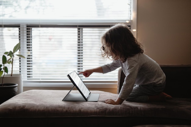 Jovem usando laptop enquanto está sentado no sofá em casa