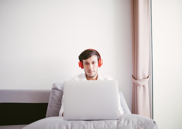 Jovem usando laptop na cama em casa