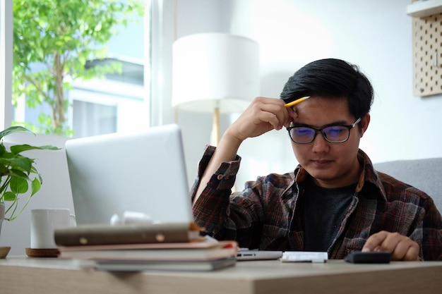 Jovem usando laptop no escritório em casa
