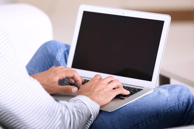 Jovem usando o laptop em casa