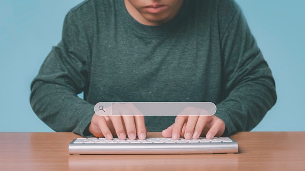 Jovem usando o teclado do computador para pesquisar informações. isolado sobre fundo azul.