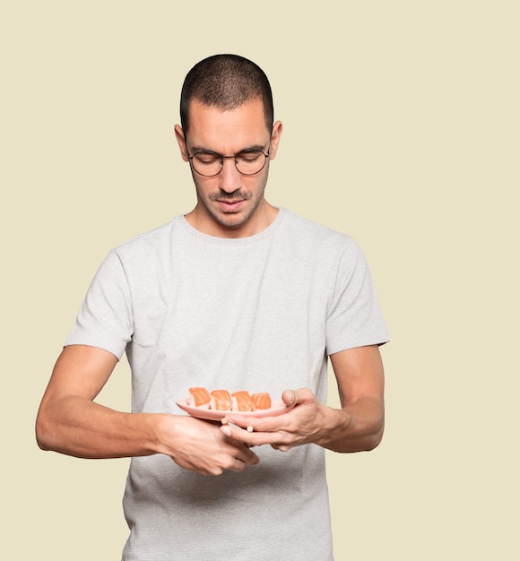 Jovem usando pauzinhos para comer sushi