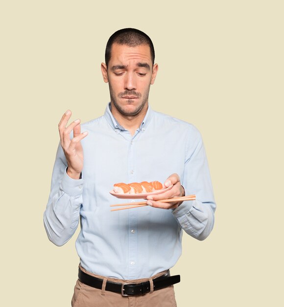 Jovem usando pauzinhos para comer sushi