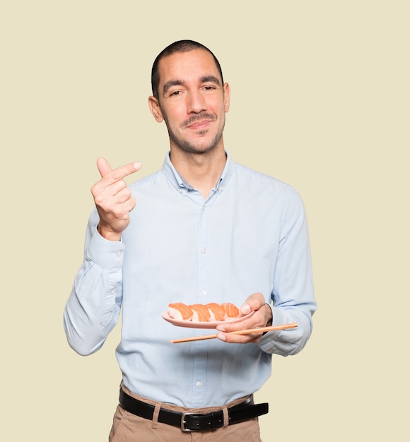 Jovem usando pauzinhos para comer sushi