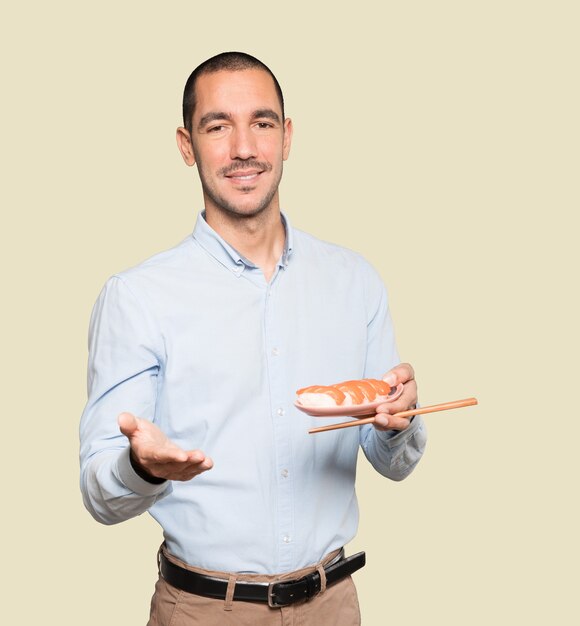 Jovem usando pauzinhos para comer sushi