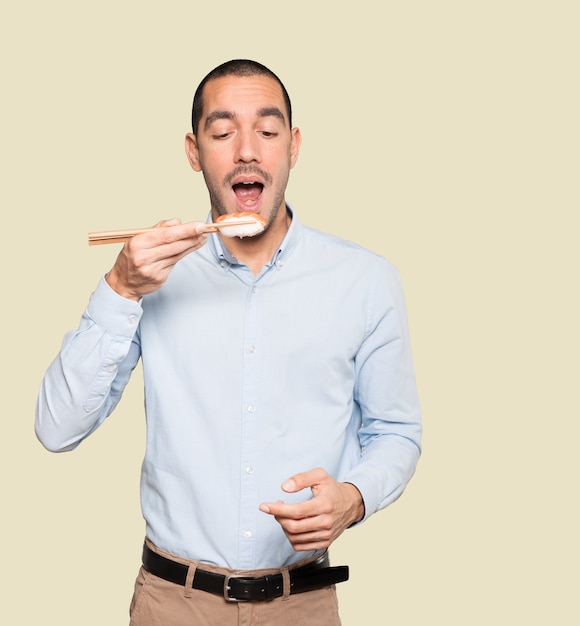 Jovem usando pauzinhos para comer sushi