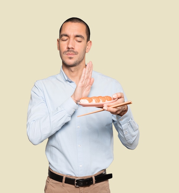 Jovem usando pauzinhos para comer sushi