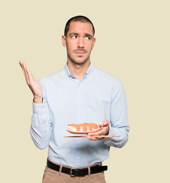 Jovem usando pauzinhos para comer sushi