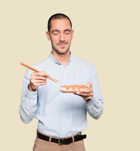 Jovem usando pauzinhos para comer sushi