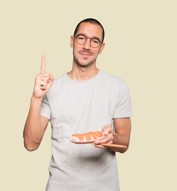 Jovem usando pauzinhos para comer sushi